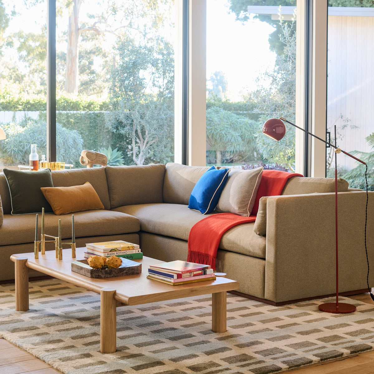 Wide view of Network Rug Swatch showcasing a geometric pattern beneath a sofa and coffee table in a sunlit living room