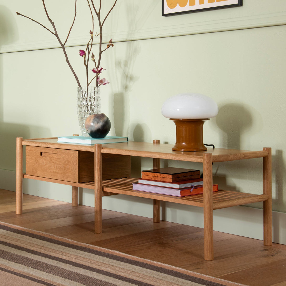 Angled view of Nora Storage Bench showcasing oak frame, lower shelf, and storage box against a pale green wall