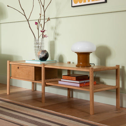 Angled view of Nora Storage Bench showcasing oak frame, lower shelf, and storage box against a pale green wall