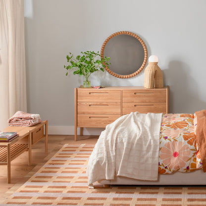 Nora Storage Bench styled with books and a folded blanket in a warm, modern bedroom