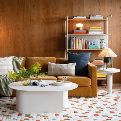 Pixel rug with a geometric pattern in a cozy living room with a sofa, coffee table, and bookshelf