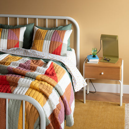 Close-up of Thistle Percale sheet set showing hand-drawn thistle print on percale with green pillow and nightstand