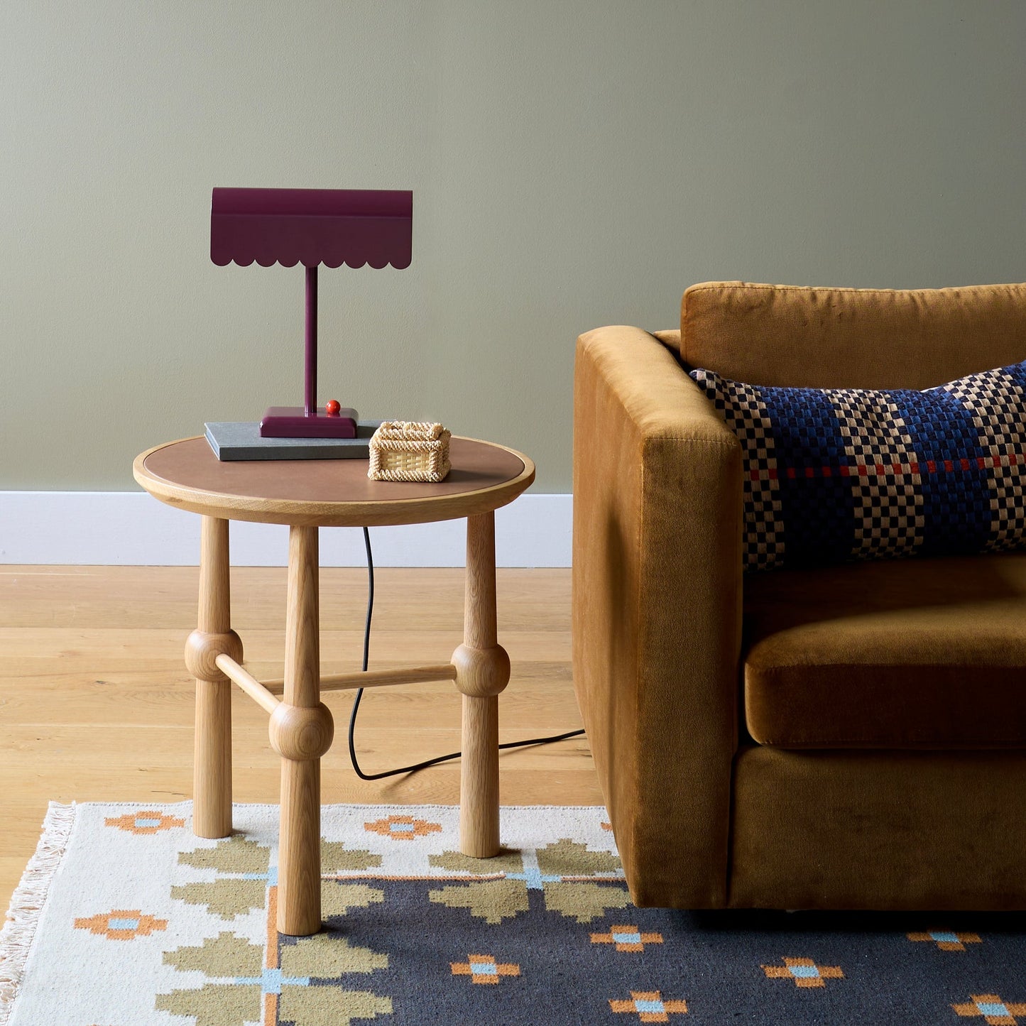Flora Wool Flatweave Rug partially visible under a round oak side table beside a mustard sofa in a styled living room