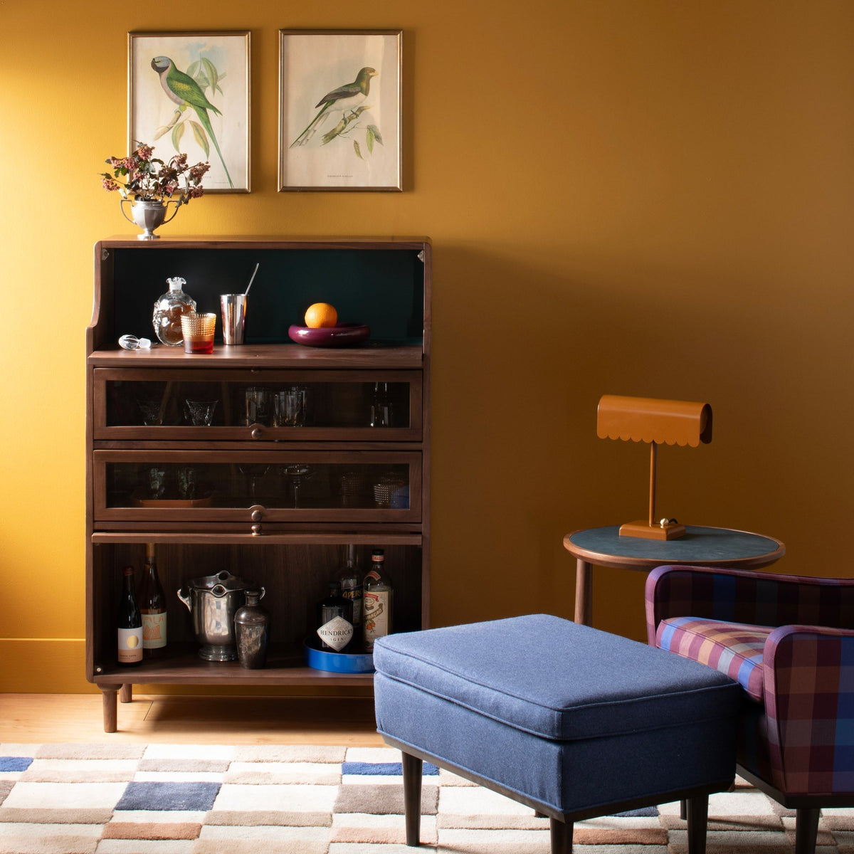 Front view of Peggy Cabinet showcasing dark wood, glass-fronted storage, and open shelving in a warm living room