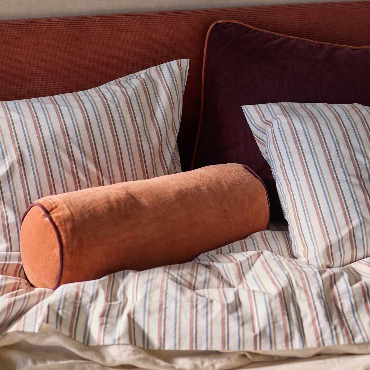 Close-up view of Fresh Stripe Sheet Set showcasing white cotton bedding with classic multicolor stripes on a bed