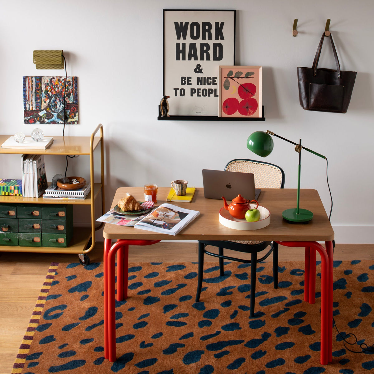 Angled view of Clare V Georges Rug showcasing jaguar print and striped border in a home office