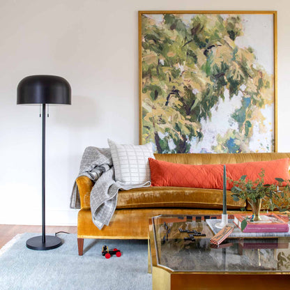 Living room with a Fog Mesa wool rug, mustard sofa, black floor lamp, and framed artwork
