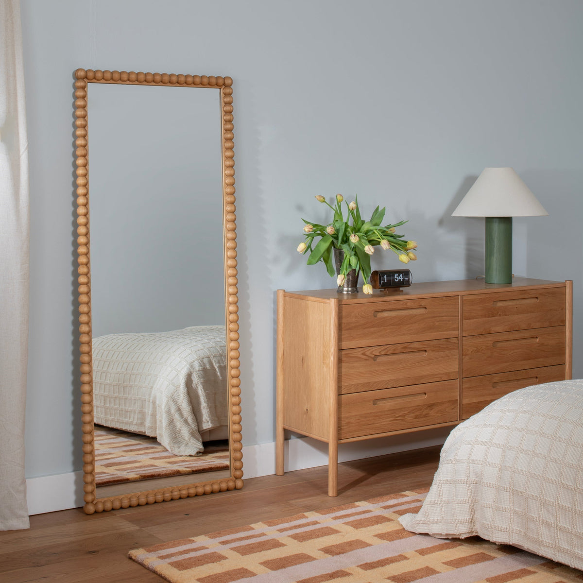 Styled view of Network Tufted Wool Rug showcasing its terracotta geometric pattern in a bedroom