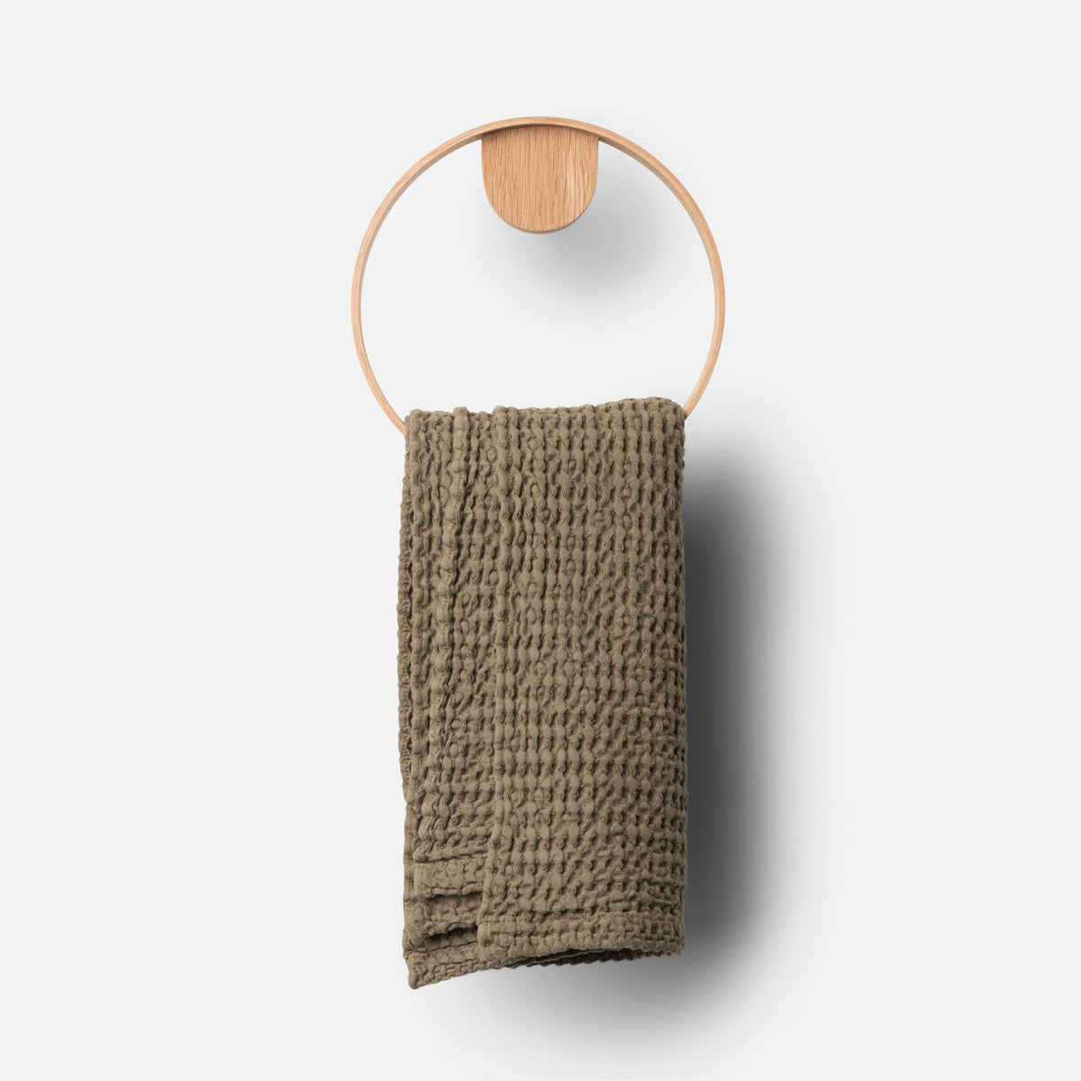 Front view of Oak Towel Ring showcasing its round oak and stainless steel design with a textured towel on a light gray background