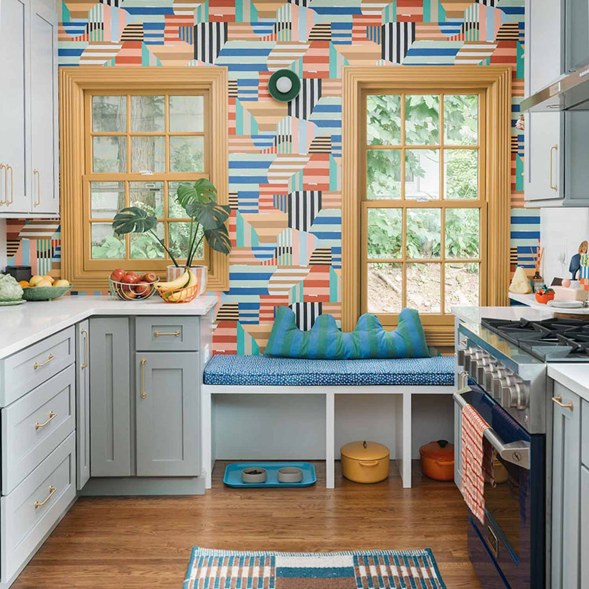 Kitchen with colorful geometric Parker Pull wallpaper, wood-trimmed windows, and a cushioned window seat