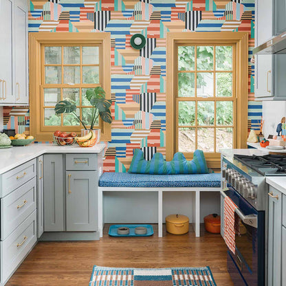 Kitchen with colorful geometric Parker Pull wallpaper, wood-trimmed windows, and a cushioned window seat