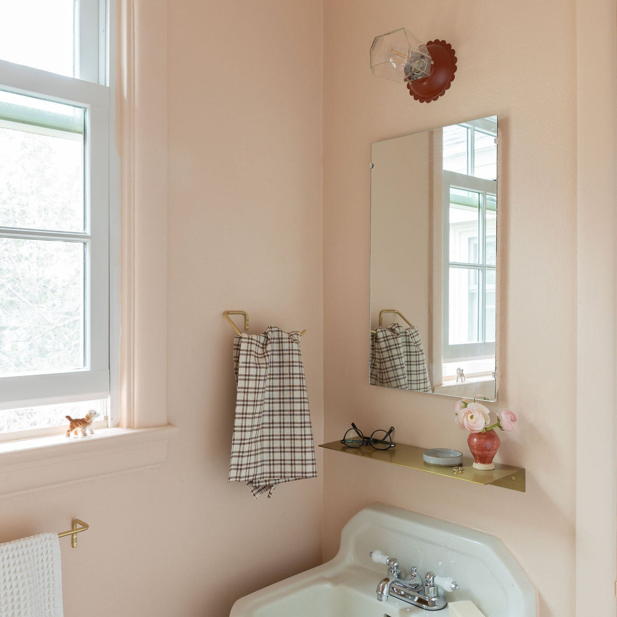 View of Mara Towel Holder showcasing its brass finish and hanging towel with a bathroom background