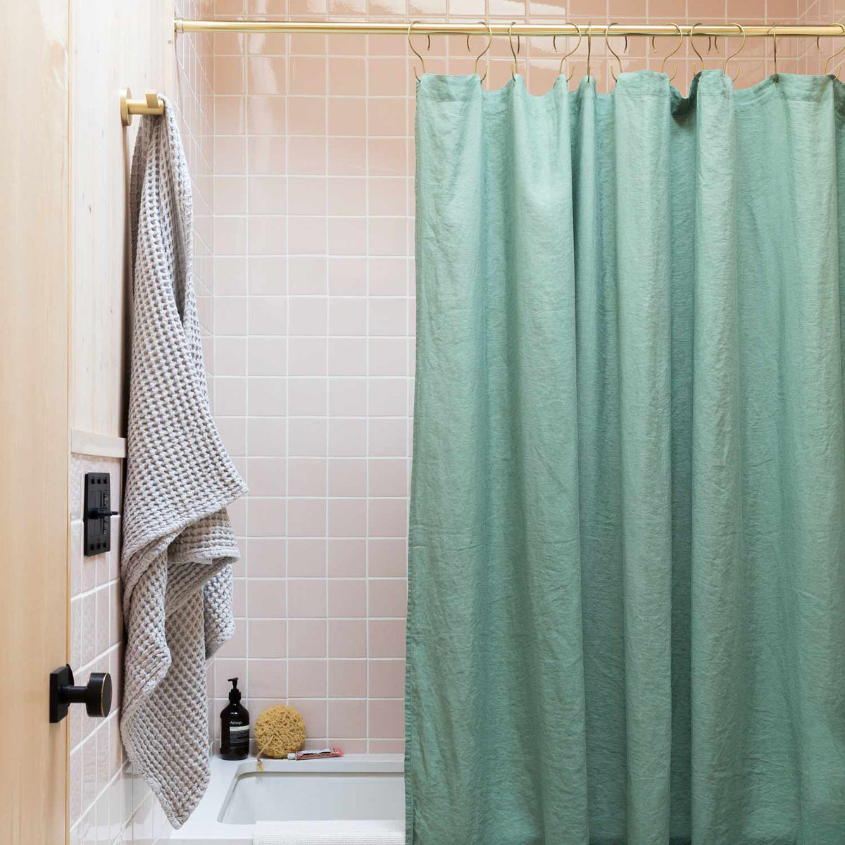 Front view of Laurel linen shower curtain showcasing textured fabric in a tiled bathroom