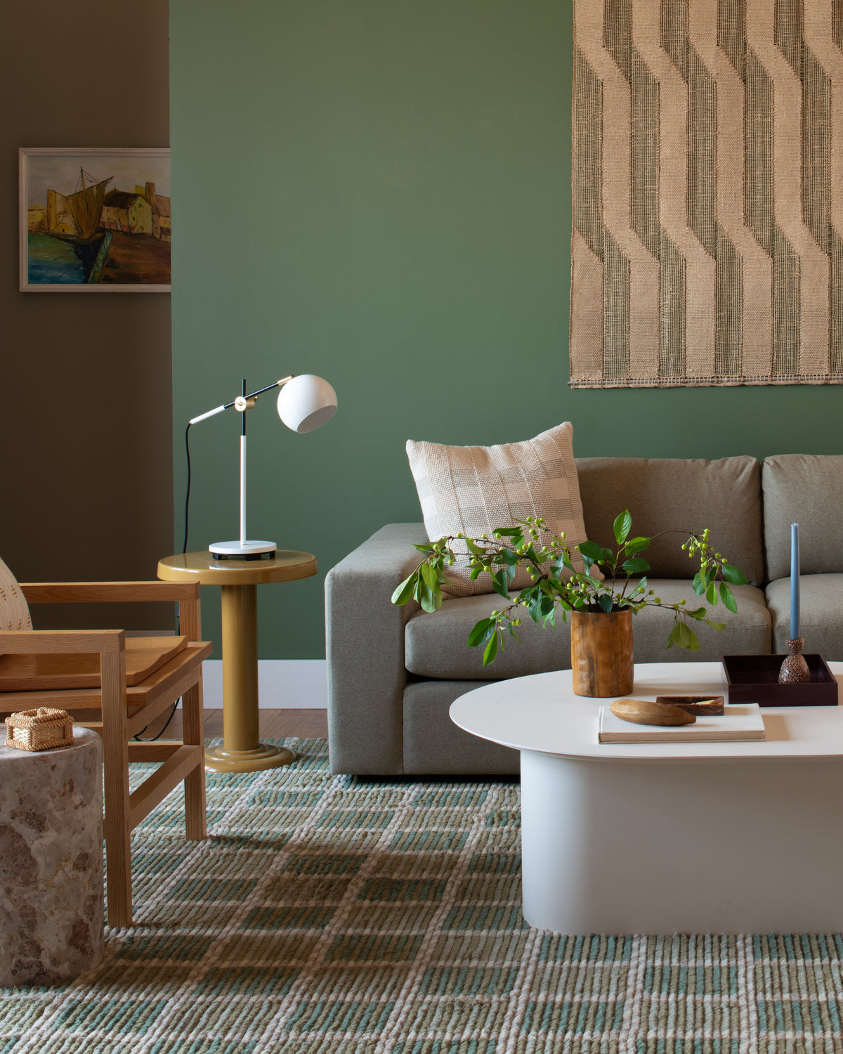 Isaac Desk Lamp displayed on a side table beside a sofa in a colorful living room