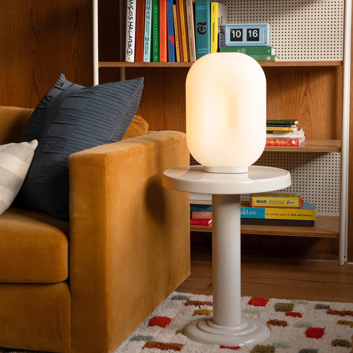 Natural Pixel Rug with a colorful geometric pattern beneath a white pedestal table in a cozy living room