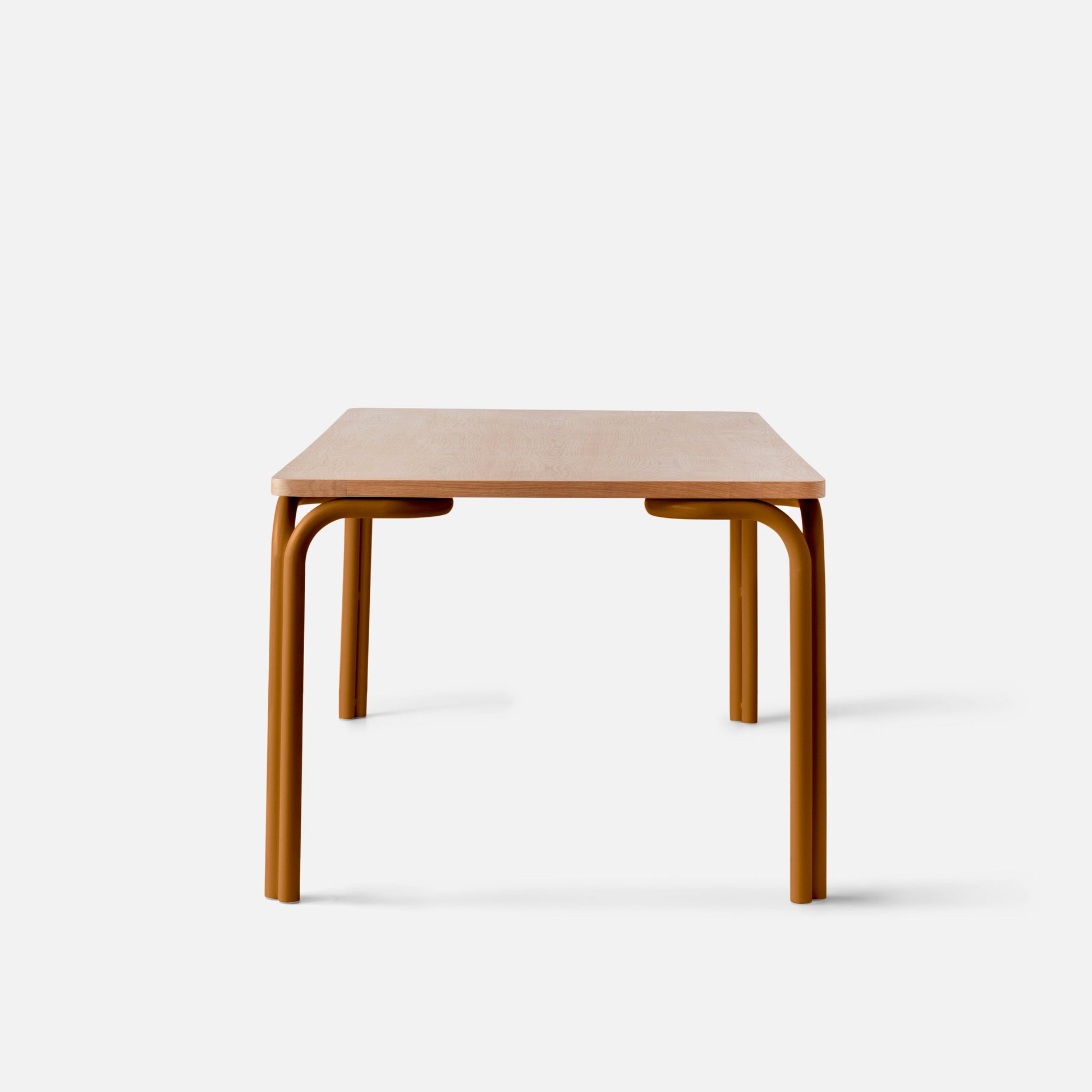 Front view of Forma Dining Table showcasing light oak tabletop and curved rust-colored tubular legs on white background