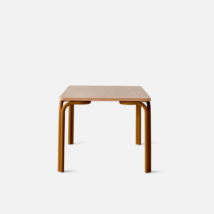 Front view of Forma Dining Table showcasing light oak rectangular top and mustard-colored tubular metal legs on white background