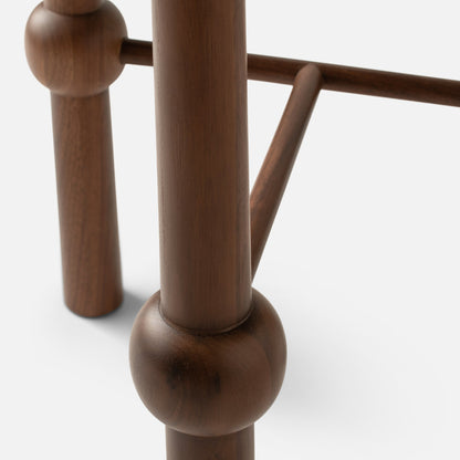 Close-up of Ann Occasional Table leg showing faceted walnut joint and round dowel stretcher on white background