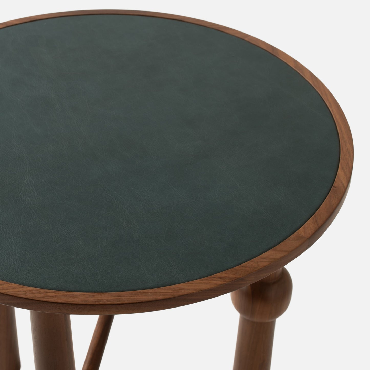 Close-up top view of Ann Occasional Table showing dark green Italian leather top and walnut rim with white background