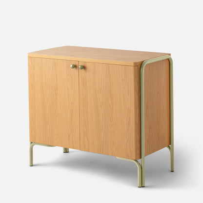 Angled view of Forma Cabinet showing oak-veneer doors, round green knobs, and powder-coated green steel legs on a white background