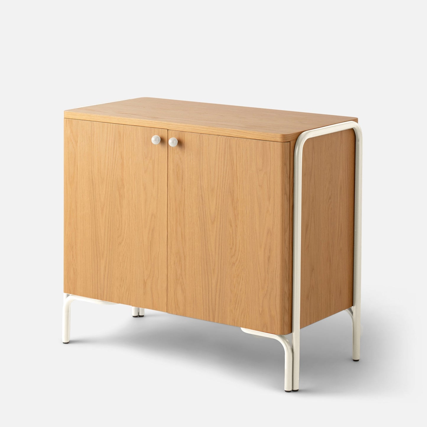 Angled top-front view of Forma Cabinet with oak-veneer doors, white knobs, and white steel frame on light gray background