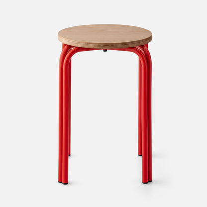 Close-up of Forma Stool showing white oak top with plywood edge and red powder-coated steel legs on white background