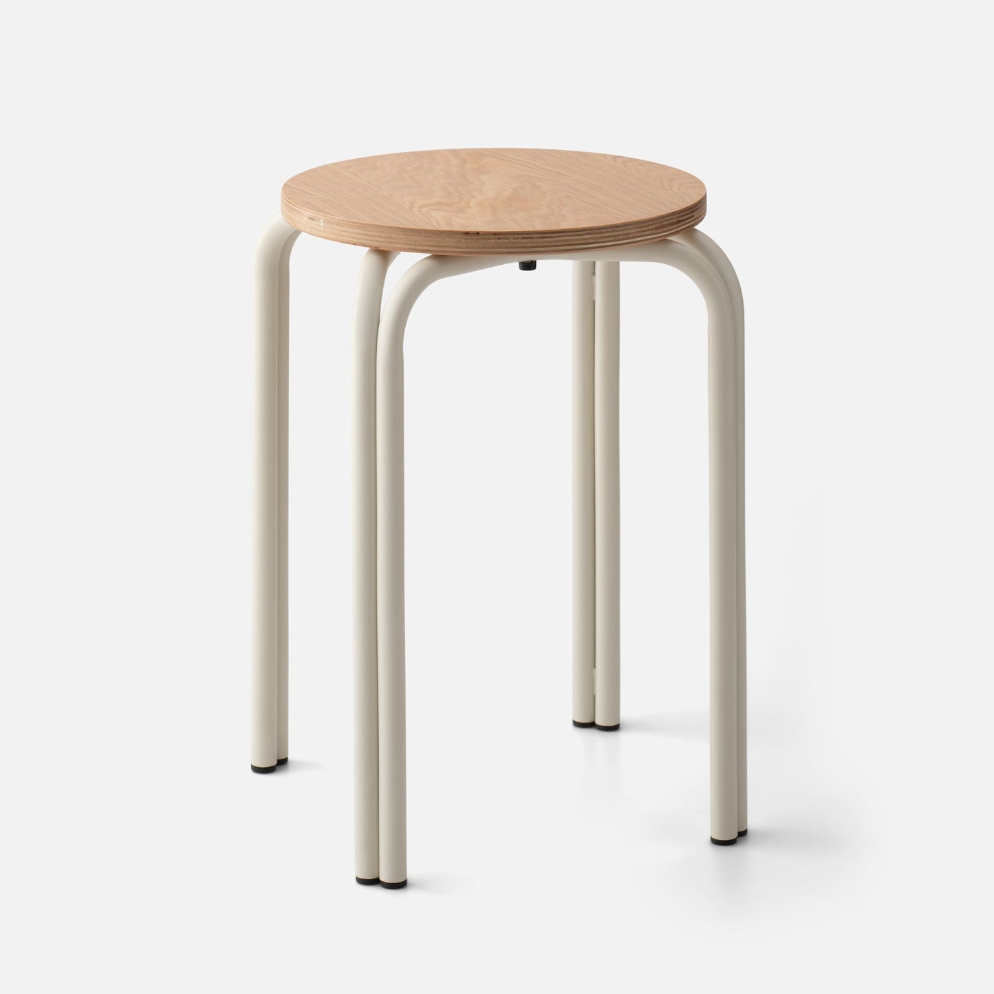 Close-up front view of Forma Stool showing round plywood seat and cream tubular metal legs on white background