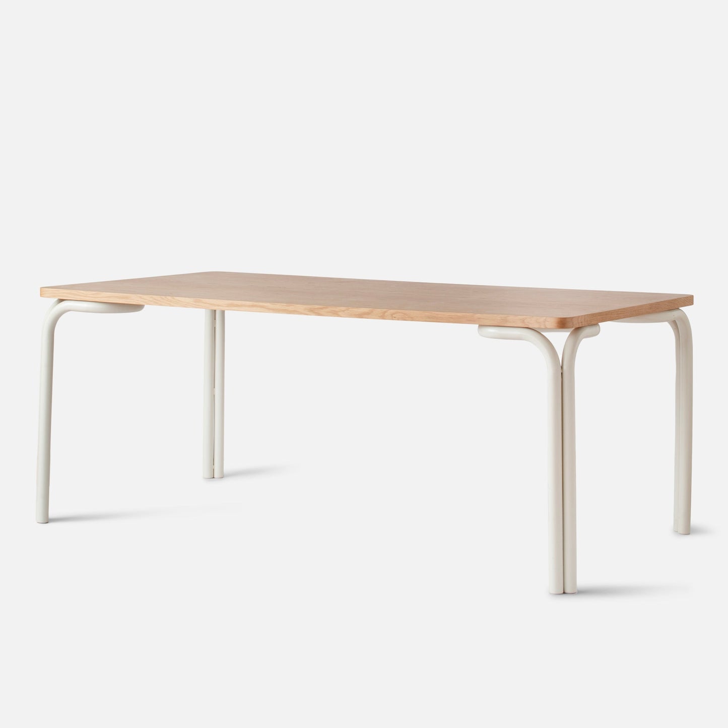 Front three-quarter view of Forma Dining Table showing light wood top and cream tubular metal legs on a white background