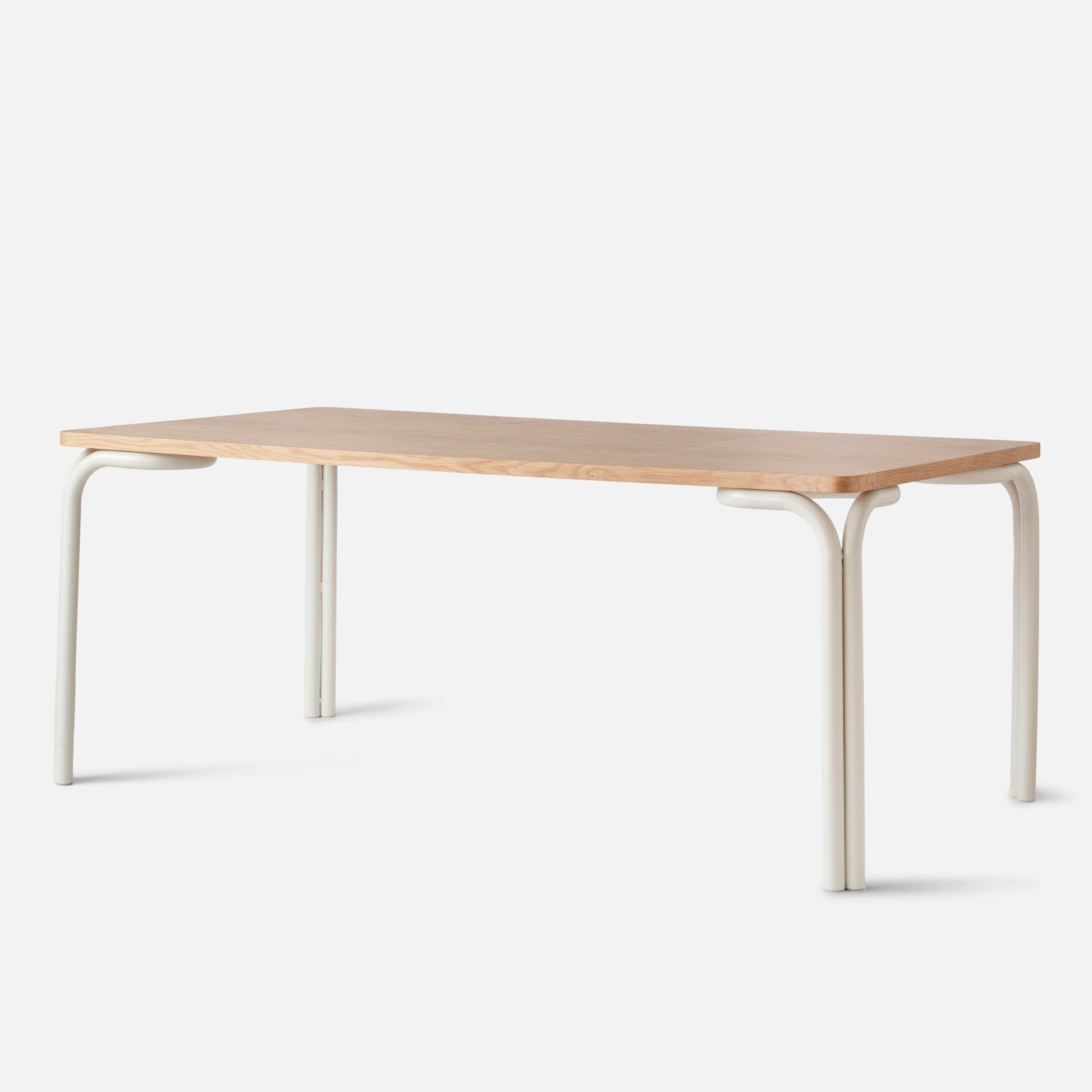 Front three-quarter view of Forma Dining Table showing light wood top and cream tubular metal legs on a white background