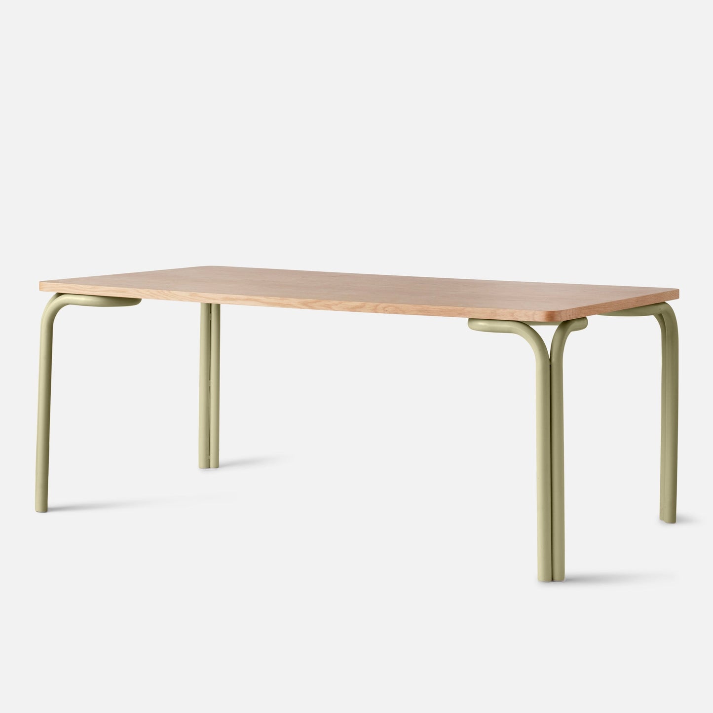 Angled side view of Forma Dining Table showcasing a light wood top and sage green curved metal legs on a white background