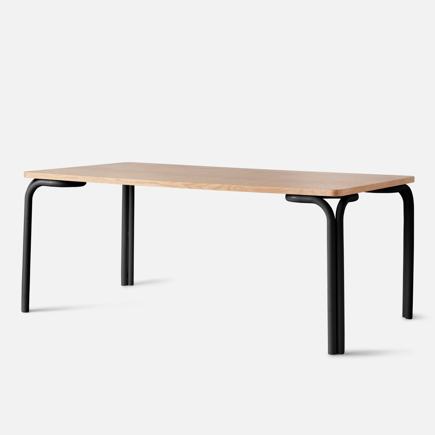Angled view of Forma Dining Table showing a butterscotch satin wood top and black bent-metal legs on white background
