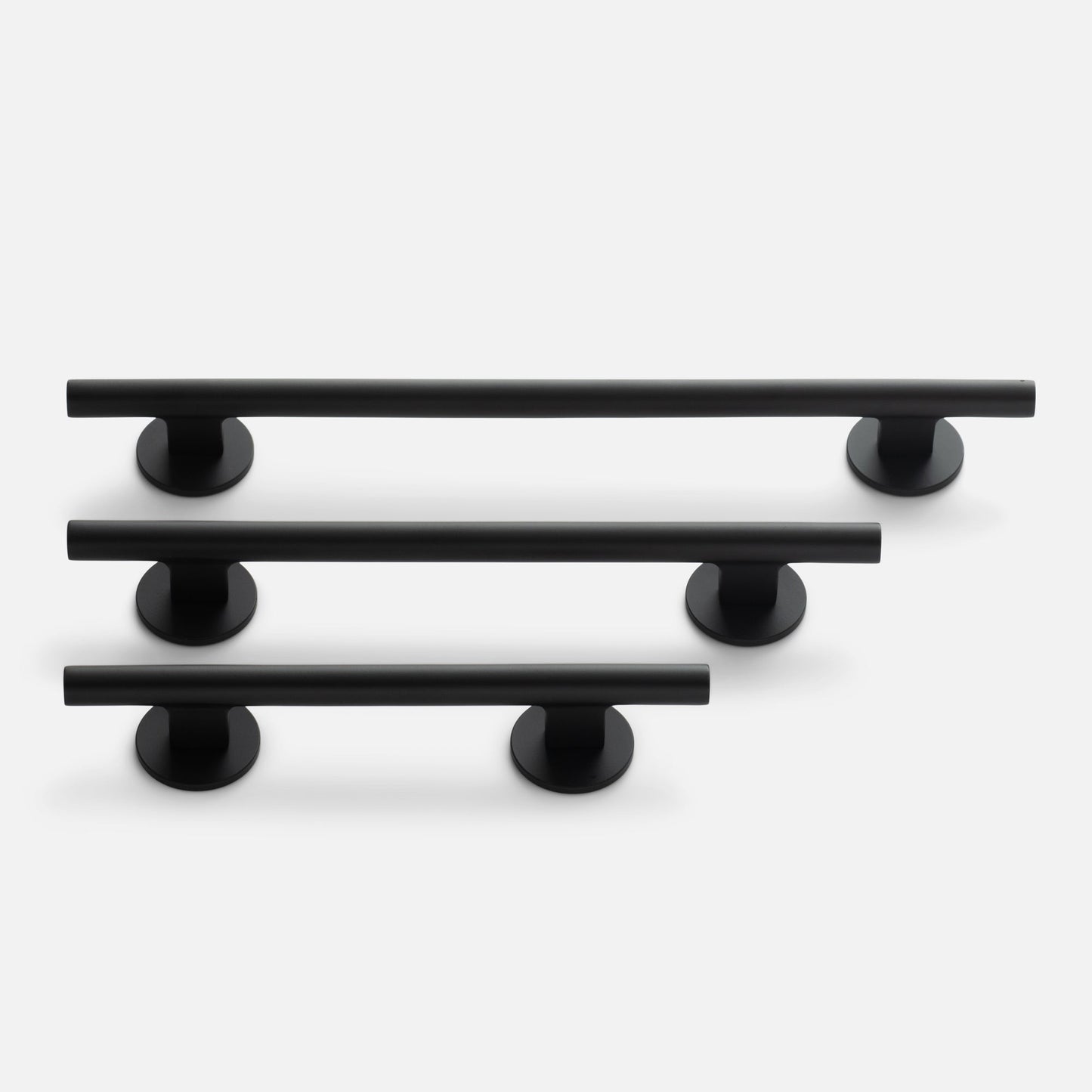 Angled view of Galley Pull set in three sizes showcasing matte black tubular bars with round mounts on a light gray background