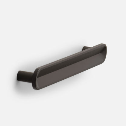 Angled front view of Rhone cabinet pull showing its rounded rectangular bar and tapered ends in matte dark bronze on a light gray background